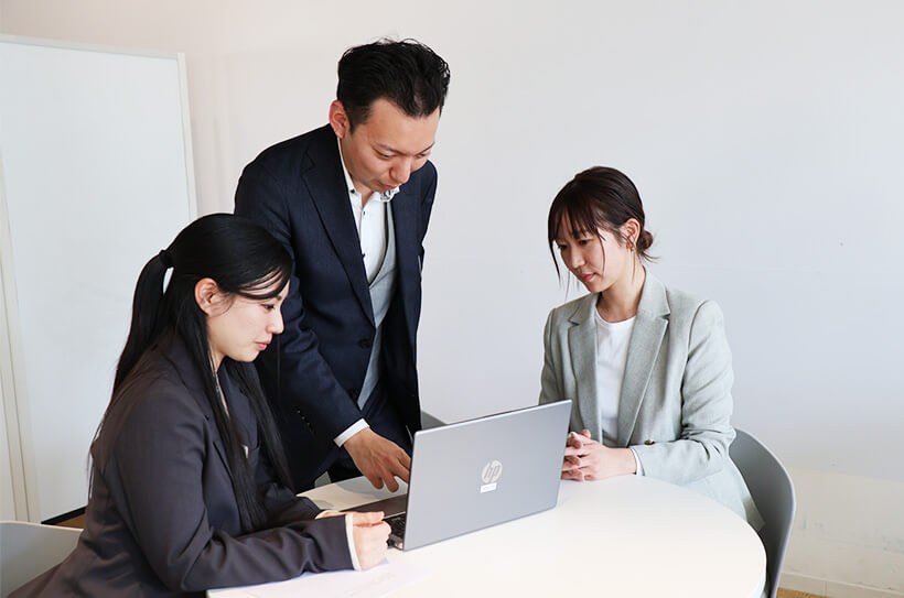 パソコンの周りで商談をしている様子